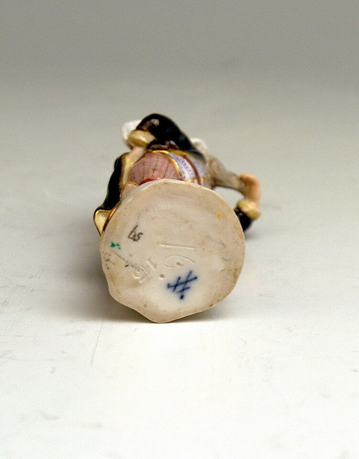 MEISSEN FIGUR VERKLEIDETE AMORETTE GEFLÜGELTER BÄRTIGER PUTTO MIT ZIPFELMÜTZE